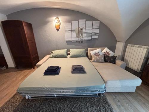 a large bed with two towels on it in a room at Appartamento Grangia Rigat, Bousson, Cesana Torinese in Bousson