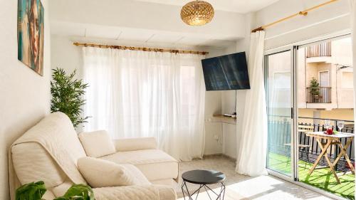 a living room with a couch and a window at APARTAMENTO SOL Y PLAYA in Santa Pola