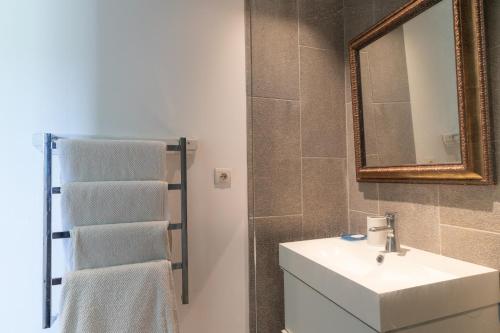 a bathroom with a sink and a mirror and towels at Le Refuge in Patrimonio