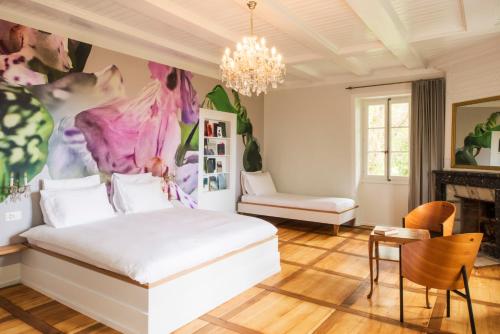 a bedroom with a bed and a painting on the wall at Auberge aux 4 Vents in Fribourg