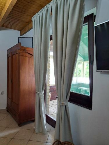 a window with curtains in a room at Piknik Garden in Senta