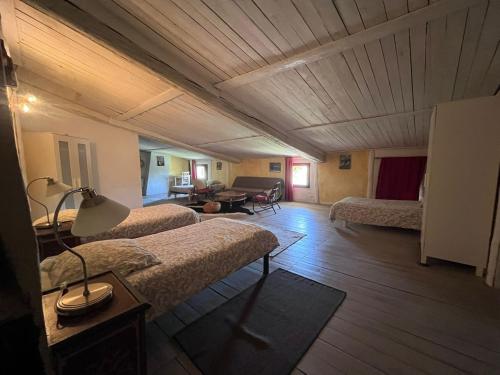 a room with two beds and a living room at Chambres et table d'hôtes Au Brabo in Mormoiron