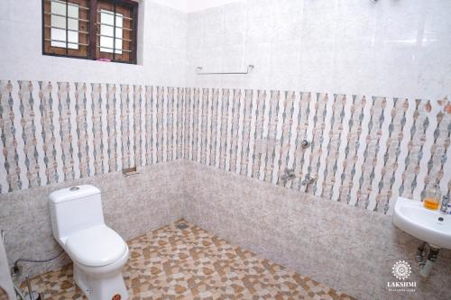 a bathroom with a toilet and a sink at Lakshmi Ayurveda Retreat in Kovalam