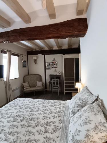 a bedroom with a bed and a chair and a table at La Chaumière en Bellevue in Muzillac