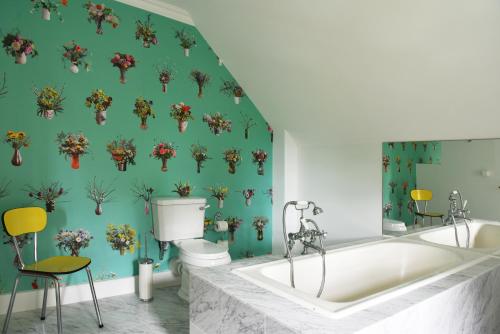 a bathroom with a tub and a green wall at Auberge aux 4 Vents in Fribourg