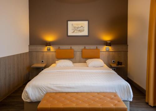 ein Schlafzimmer mit einem großen Bett und zwei orangefarbenen Stühlen in der Unterkunft Blanckthys Hotel Voeren in Voeren