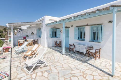a patio with chairs and a table on a house at Αστραία - με θέα στο Αιγαίο in Agios Ioannis