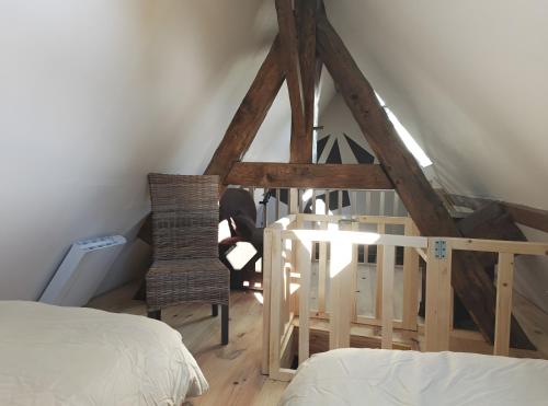 a room with a bed and a ladder and a chair at Gîte Escapade À La Voreille in Mazirat