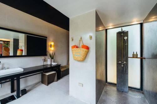 a bathroom with a sink and a mirror at Tolani Resort Koh Samui in Lamai