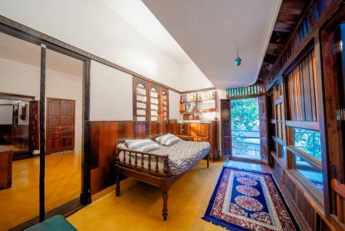 a bedroom with a bed and a rug in a room at Panackal Heritage Home in Trivandrum