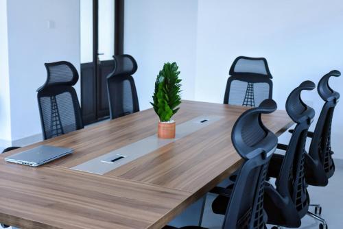 a conference room with a wooden table and black chairs at Slow Life Coliving, Hiriketiya in Dickwella