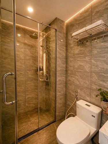 a bathroom with a toilet and a glass shower at SOLÉRA 2 Homestay in Phú Quốc