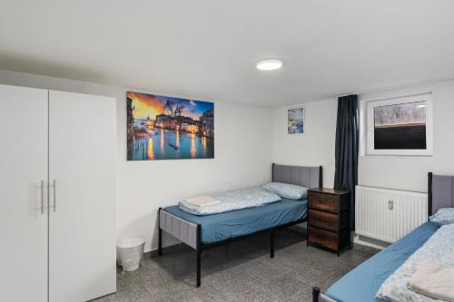 a bedroom with two beds and a painting on the wall at MK Rooms Bremen in Bremen