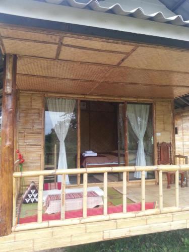 a screened in porch of a log cabin with curtains at Tulip Resort Pai in Pai