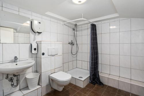 a bathroom with a toilet a sink and a shower at MK Rooms Bremen in Bremen