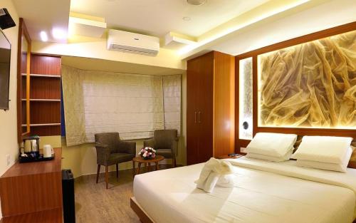 a hotel room with a bed and a desk and a chair at Hotel Sea Blue MALLAPPALLY in Vennikulam