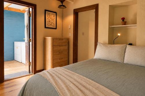 a bedroom with a bed and a door to a bathroom at Boho Burrow in Monte Rio