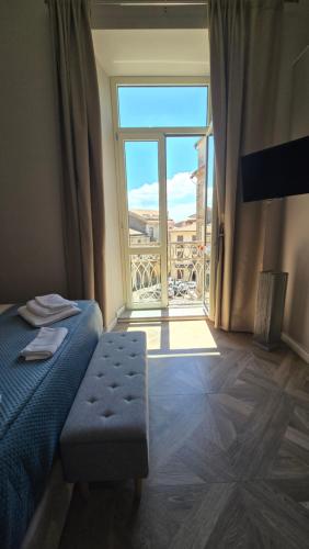 a bedroom with a bed and a large window at Numistrano Room in Lamezia Terme