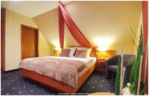 a hotel room with a bed with a canopy at Zur Linde in Heede