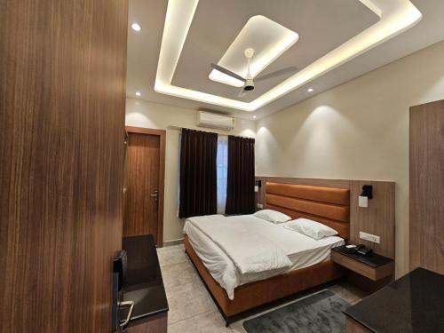 a bedroom with a bed and a ceiling fan at Hotel LimeStarow in Bijni