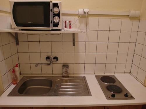 a kitchen counter with a sink and a microwave at Hotel Kačerov in Prague