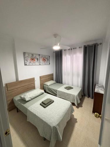 a room with two beds and a window at Tropical Salou in Salou