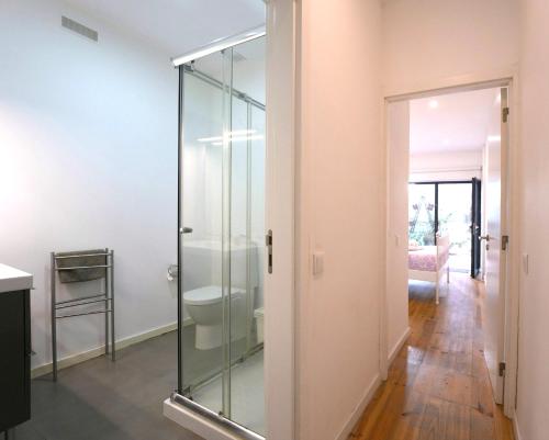 a glass shower door in a room with a hallway at Casa dos Pátios in Aveiro
