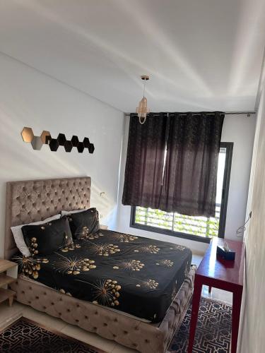a bedroom with a large bed and a window at Studio Luxe Bouznika Beach Piscine, Clim, Wi-Fi ,Check in 24h Plage 5 min in Bouznika