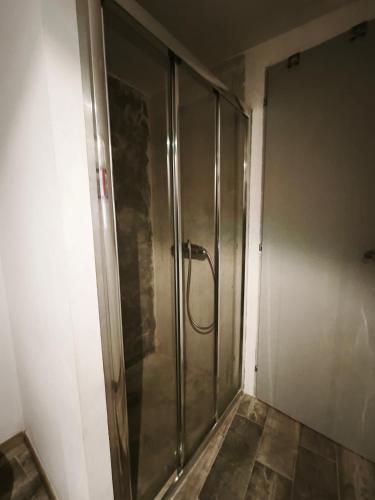 a shower stall in a room with a wall at L'aube de Pierre in Saint-Pons-de-Thomières