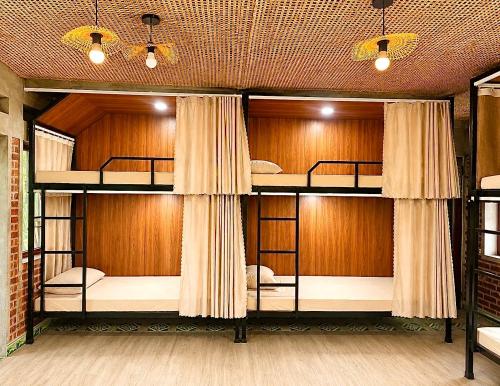 two bunk beds in a room with wooden walls at Nếp homestay in Làng Xa
