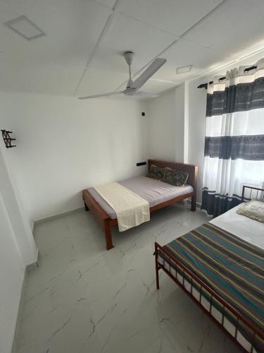 a bedroom with two beds and a ceiling at Ocean Heart Guest House in Nilaveli