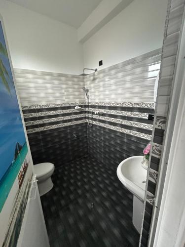a bathroom with a toilet and a sink at Ocean Heart Guest House in Nilaveli