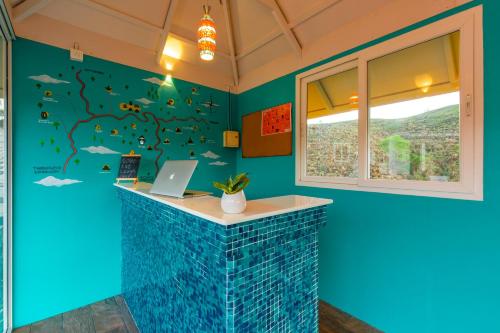 a blue room with a counter with a laptop on it at Monkey Tribe Vagamon in Vagamon