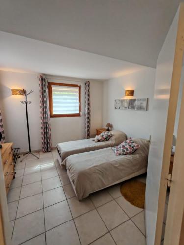 a bedroom with two beds and a window at gite villa ardeche joyeuse piscine in Joyeuse
