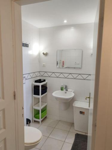 a white bathroom with a sink and a mirror at gite villa ardeche joyeuse piscine in Joyeuse