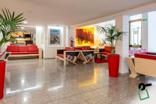 a lobby with red furniture and potted plants at Hotiday Cagliari Sant'Elena in Cagliari