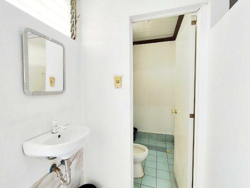 a bathroom with a sink and a toilet at OYO 1214 Cherry Travellers Inn in San Jose de Buenavista