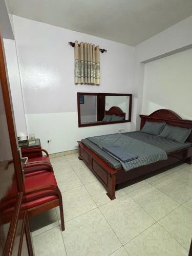 a bedroom with a bed and a red chair at Hotel Tuấn Anh in Vô Hối