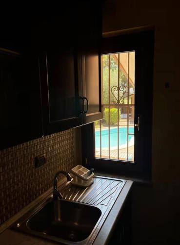 a kitchen counter with a sink and a window at Tenuta Ciaramiti Luxury Garden & Pool in Brattirò