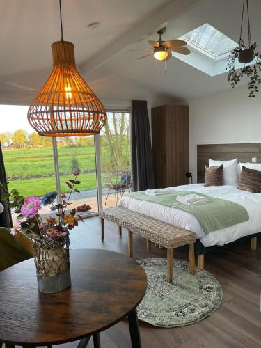a bedroom with a large bed and a table with a table sidx sidx at Grenzeloos in Doldersum
