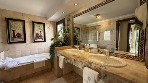 a bathroom with two sinks and a tub and a large mirror at Villa Turrion in Marbella