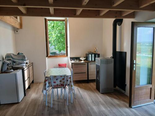 a small kitchen with a table and a stove at Gite de Labarraque in Monbahus