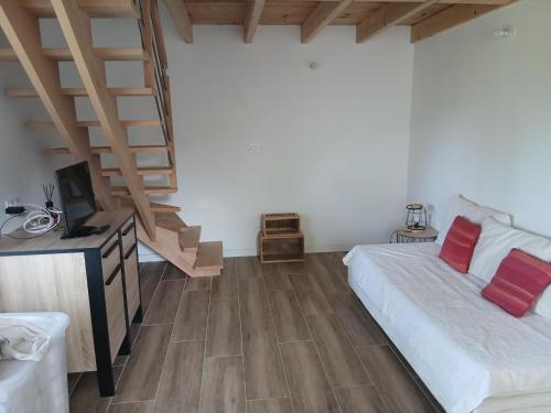 a bedroom with a bed with red pillows and stairs at Gite de Labarraque in Monbahus