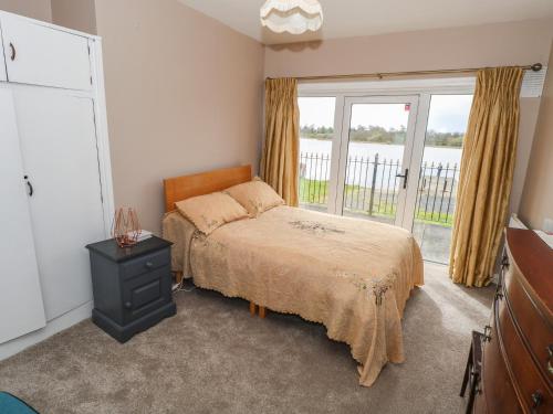 a bedroom with a bed and a window at Sweetbriar Lodge in Castlerea