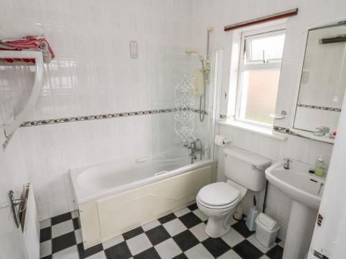 a bathroom with a toilet and a tub and a sink at Sweetbriar Lodge in Castlerea