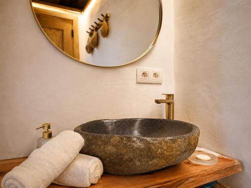 a bathroom with a stone sink and a mirror at La Paredita Casa Acentejo in Tanque
