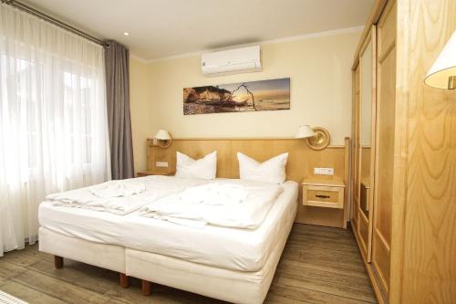 a bedroom with a white bed in a room at Bungalow Hanseatchen in Baabe