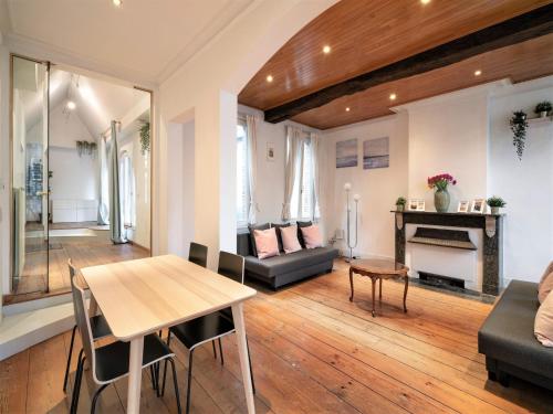a living room with a table and a fireplace at Deluxe Capital Street Stay for 12 in Antwerp