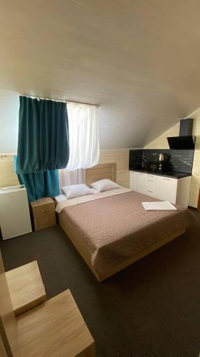 a bedroom with a large bed with a window at DiAmel in Petropavlovskaya Borshchagovka