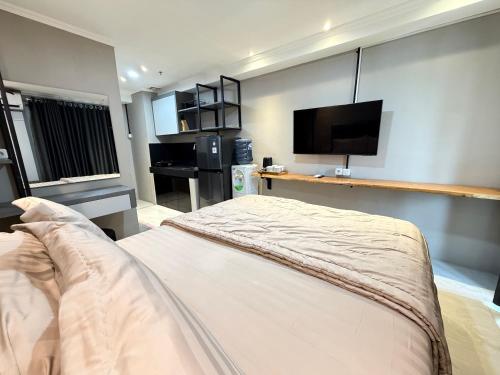 a bedroom with a bed and a flat screen tv at SkyBreeze Sentraland in Medan
